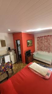 a room with two beds and a kitchen at Kitnet Da Cláudia e Geovani in Miguel Pereira