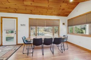 a dining room with a wooden table and chairs at Pebble on The Creek in Whittier