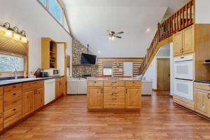 a large kitchen with wooden cabinets and a staircase at Pebble on The Creek in Whittier