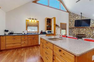 a kitchen with wooden cabinets and a counter top at Pebble on The Creek in Whittier +13 photos