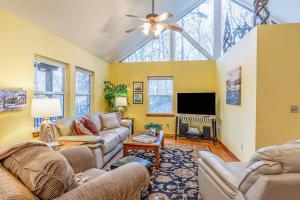 a living room with two couches and a tv at Tree Top Cabin in Sylva