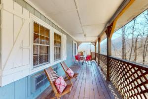 a porch with two benches and a table and chairs at Elk Valley Lodge in Maggie Valley