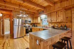 a kitchen with wooden cabinets and a stainless steel refrigerator at Forest Hideaway in Maggie Valley