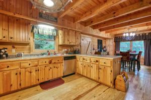 a large kitchen with wooden cabinets and a dining room at Forest Hideaway in Maggie Valley