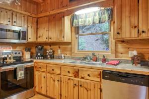 a kitchen with wooden cabinets and a sink at Forest Hideaway in Maggie Valley