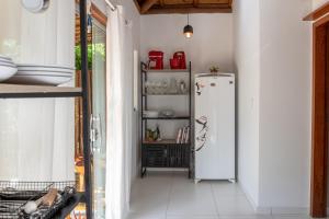 a kitchen with a white refrigerator in a room at Casa Cuca Fresca , 2 Suítes e a 400m das Piscinas Naturais reservadas in Marau +14 photos