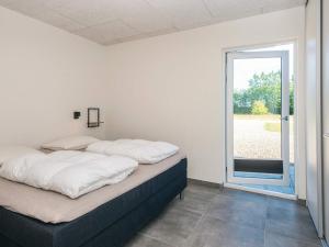 a bedroom with two beds and a large window at 4 star holiday home in Ringkøbing in Ringkøbing