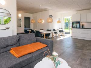 a living room with a couch and a dining room at 4 star holiday home in Ringkøbing in Ringkøbing