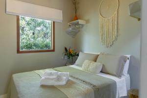 a bedroom with a bed with two towels on it at Casa Cuca Fresca , 2 Suítes e a 400m das Piscinas Naturais reservadas in Marau