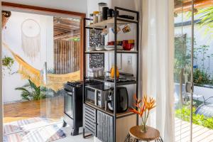 a kitchen with a stove and a microwave at Casa Cuca Fresca , 2 Suítes e a 400m das Piscinas Naturais reservadas in Marau
