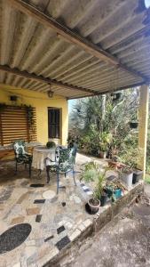 a patio with two chairs and a table with plants at Kitnet Da Cláudia e Geovani in Miguel Pereira +1 photo