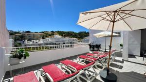 a group of lounge chairs and an umbrella on a balcony at Liberdade - Near the beach - 6 Pax - Albufeira in Albufeira