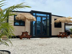 a tiny house with two picnic tables and glass doors at Babus Villas del Sol in El Combate
