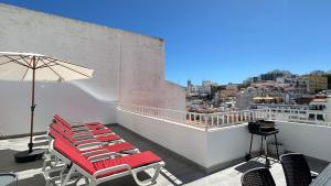 a balcony with lounge chairs and an umbrella at Liberdade - Near the beach - 6 Pax - Albufeira in Albufeira