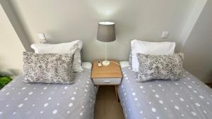 two beds with pillows and a night stand in a bedroom at Liberdade - Near the beach - 6 Pax - Albufeira in Albufeira