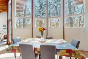 a dining room with a table and chairs and windows at Red Fox Lair in Franklin