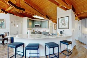 a kitchen with a large island with blue stools at Red Fox Lair in Franklin +17 photos