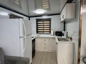 a white kitchen with a refrigerator and a sink at Babus Villas del Sol in El Combate