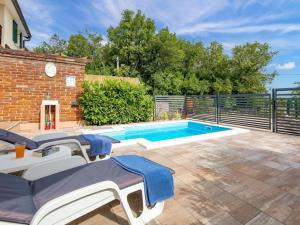 a swimming pool with lounge chairs next to a brick building at Kuca za odmor Vila Agnes in Županje