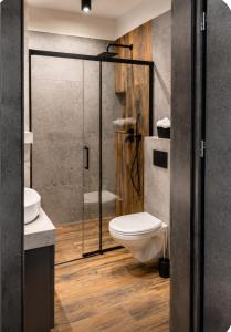 a bathroom with a toilet and a glass shower at Apartamenty Zator Jaśminowa in Zator +10 photos
