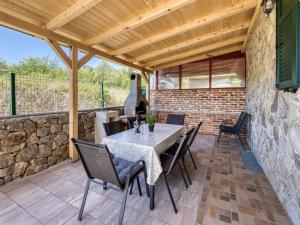 a patio with a table and chairs and a stone wall at Kuca za odmor Vila Agnes in Županje