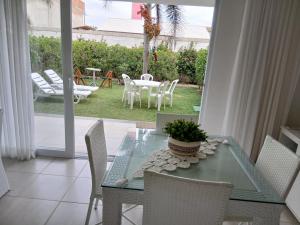 a dining room with a glass table and chairs at Apto 2/4 resort TreeBies- Subaúma in Subaúma