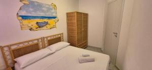 a bedroom with a bed and a painting on the wall at Residence Villa delle Rose in Lampedusa +25 photos