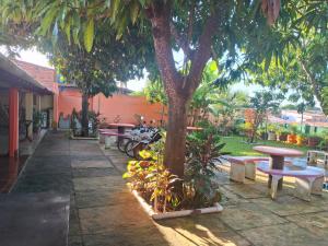 a group of tables and benches under a tree at Hospedagem Aconchego do Lar in Barreirinhas