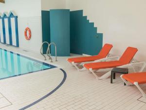a pool with two chairs and a swimming pool at ibis Styles St Gilles Croix de Vie centre-ville in Saint-Gilles-Croix-de-Vie