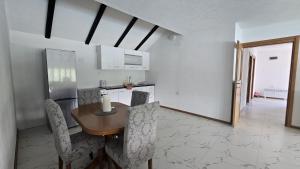 a kitchen with a wooden table and some chairs at Captains Seherzada Apartment in Železnička Stanica Ostrožac