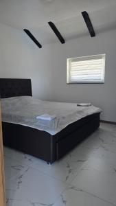a bedroom with a bed in a room with a window at Captains Seherzada Apartment in Železnička Stanica Ostrožac