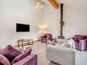 a living room with purple furniture and a tv at 4 Bed in Forton oc-81290 in Forton
