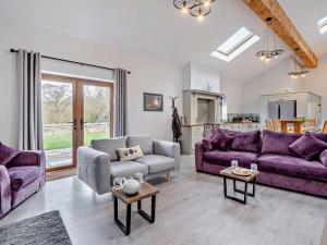 a living room with purple couches and a kitchen at 4 Bed in Forton oc-81290 in Forton
