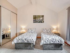 a bedroom with two beds and two lamps and a mirror at 4 Bed in Forton oc-81290 in Forton