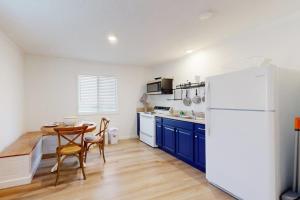 a kitchen with a table and a white refrigerator at The Crocket Fortune in Murphy
