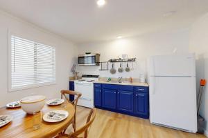 a kitchen with a table and a white refrigerator at The Crocket Fortune in Murphy