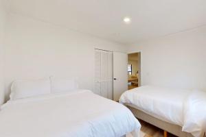 two beds in a bedroom with white walls at The Crocket Fortune in Murphy