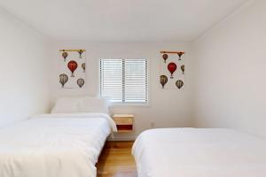 two beds in a white room with a window at The Crocket Fortune in Murphy +8 photos