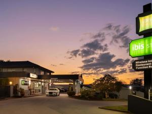 a car is parked in front of a gas station at ibis Styles Orange in Orange