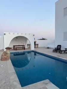 a swimming pool in front of a white building at villa mellita in Mellita