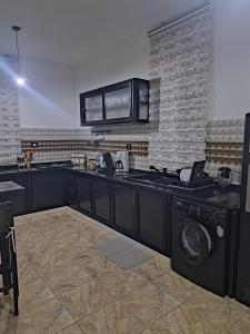 a kitchen with a sink and a washing machine at villa mellita in Mellita