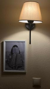 a lamp hanging on a wall with a picture at Resort Dimitris in Alexandroupoli +20 photos