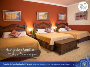 a hotel room with two beds with orange walls at Posada de San Carlos del Parque in Antigua Guatemala