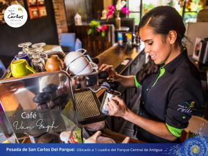 a woman preparing food in a restaurant kitchen at Posada de San Carlos del Parque in Antigua Guatemala