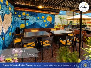 a restaurant with a mural on the wall at Posada de San Carlos del Parque in Antigua Guatemala