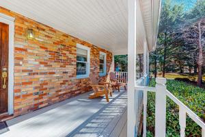 a brick house with a porch with rocking chairs at Brevard Bungalow in Brevard