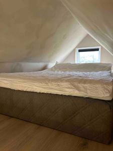 a bed in a small room with a window at Cozy cottage with a view in Hella