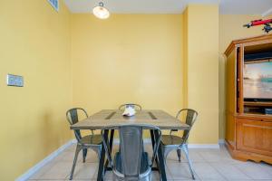 a table and chairs in a room with a tv at The Dunes 503 in Gulf Shores