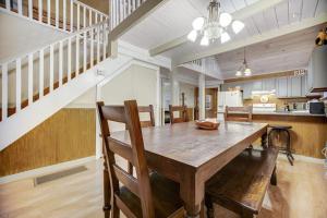a dining room with a wooden table and stairs at Along the River Cottage in Cullowhee