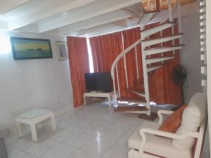 a living room with a spiral staircase and a television at Mystic Ridge Ochi in Ocho Rios